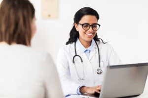 Picture of a woman talking to a doctor during a well-woman care visit.